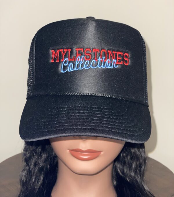 Mannequin wearing a black Mylestones Collection hat with red and light blue lettering